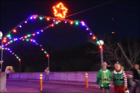Santa’s Elves wait to guide your drive under the lights.