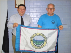 Designer and producer Tod Hanger and Mayor Luther Lewallen are seen holding the new town flag.