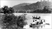 Circa 1910, ladies and gentlemen of old Alderson take a weekend outing on the Greenbrier with the iron bridge in the background.